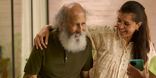 Cuidadora ayudando a una persona mayor a caminar mientras que habla con el Cuidadora ayudando a una persona mayor a caminar mientras que habla con el